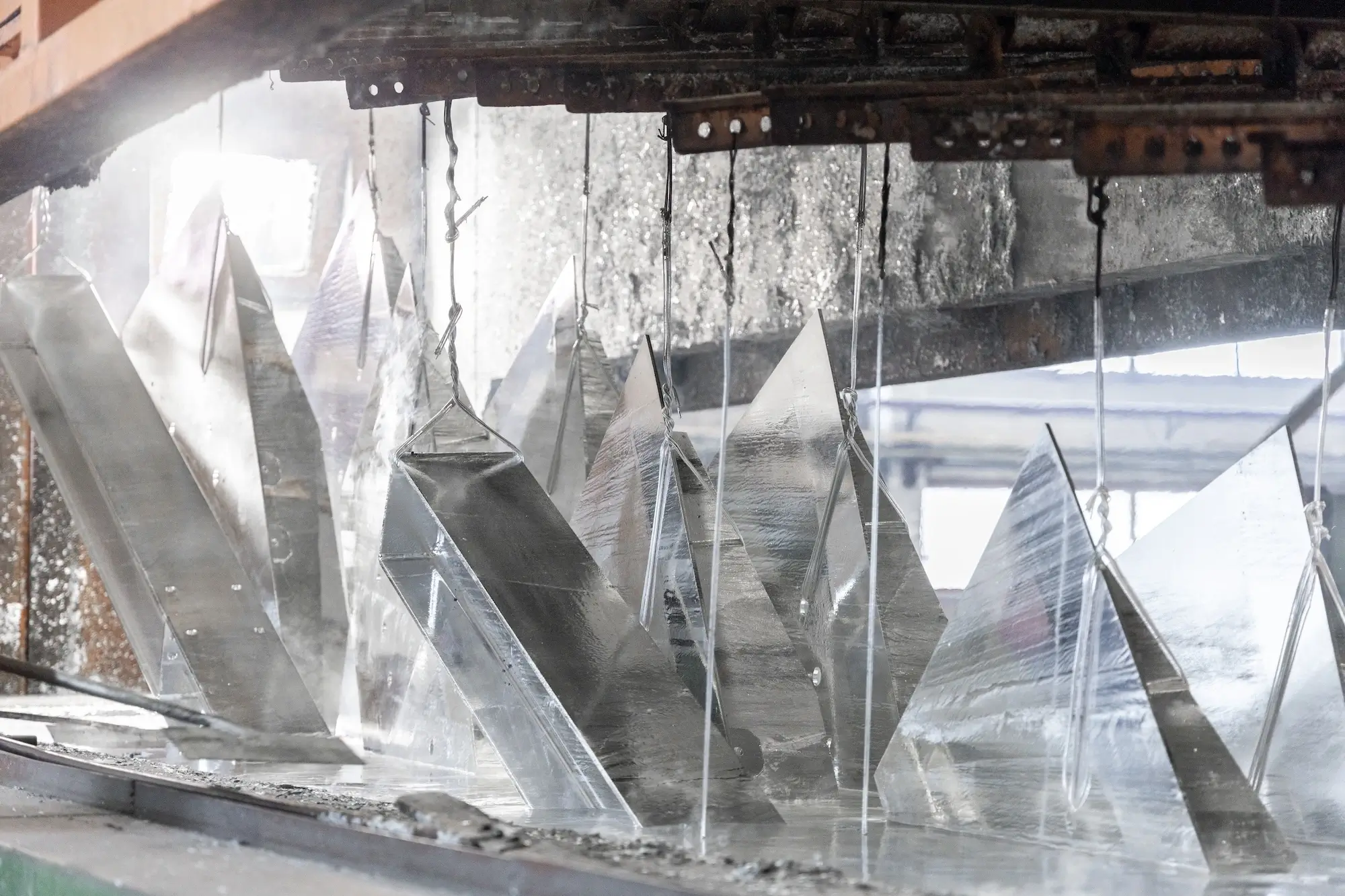 Freshly hot-dip galvanized metal parts cooling on the production line after exiting the bath.