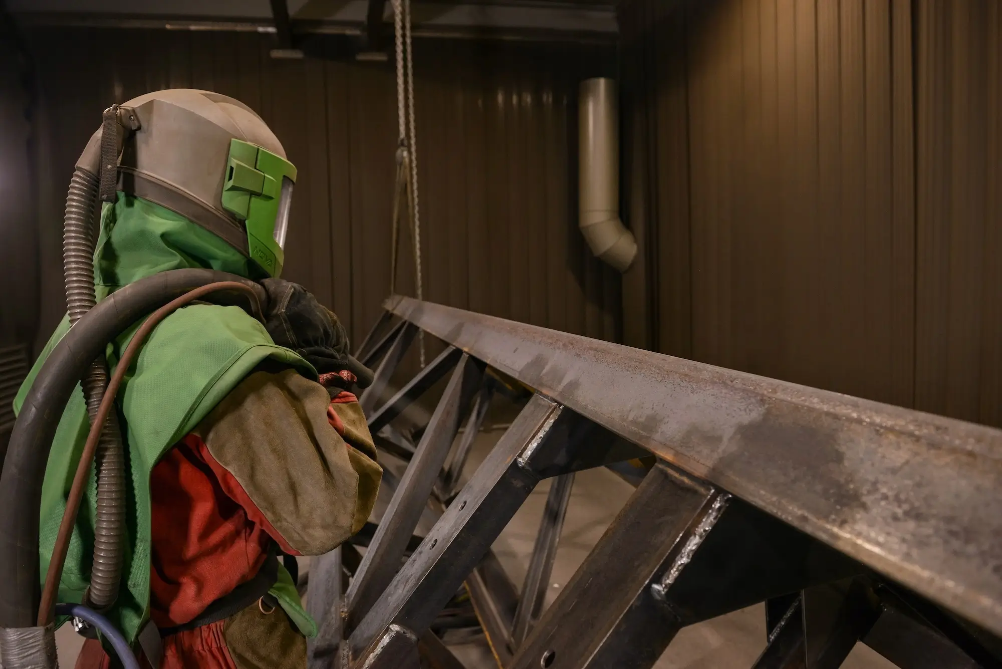 Metal surface preparation using abrasive cleaning (shot blasting) before painting.