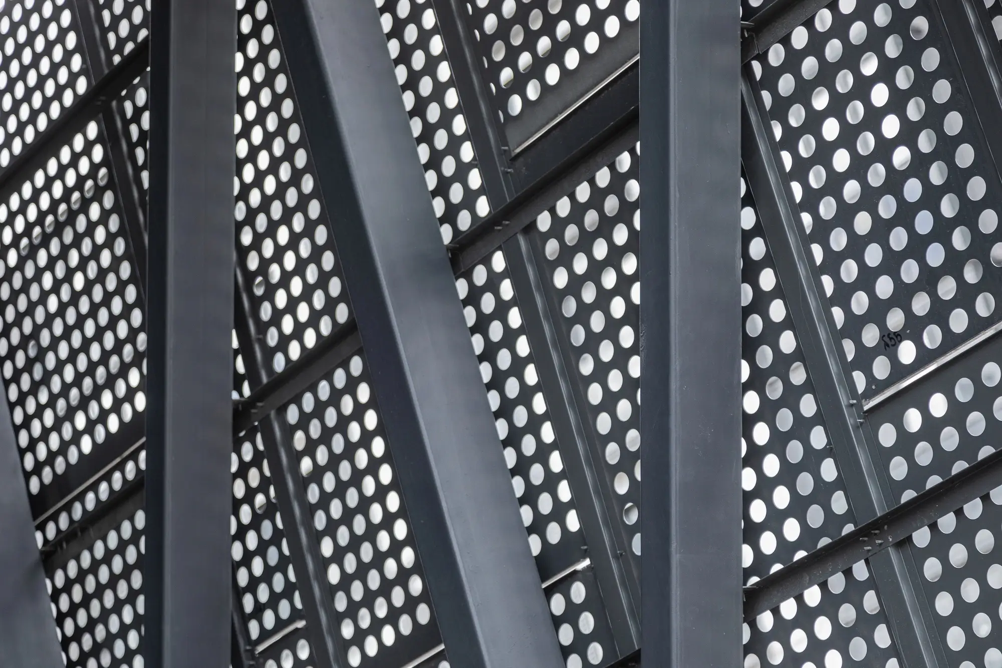 Black powder-coated perforated metal panels for architectural solutions.